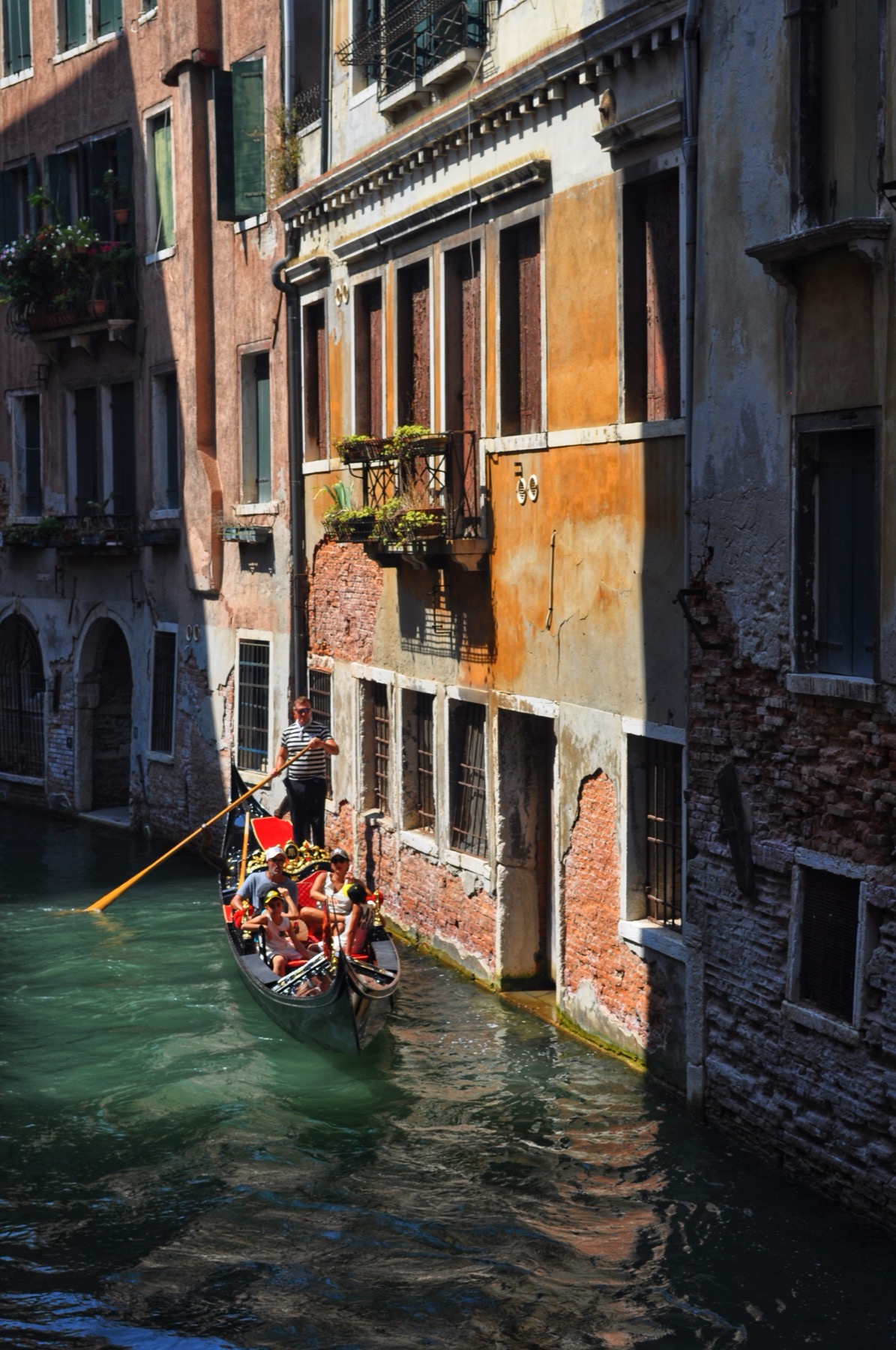A gondola gliding past weathered brick facades in Venice